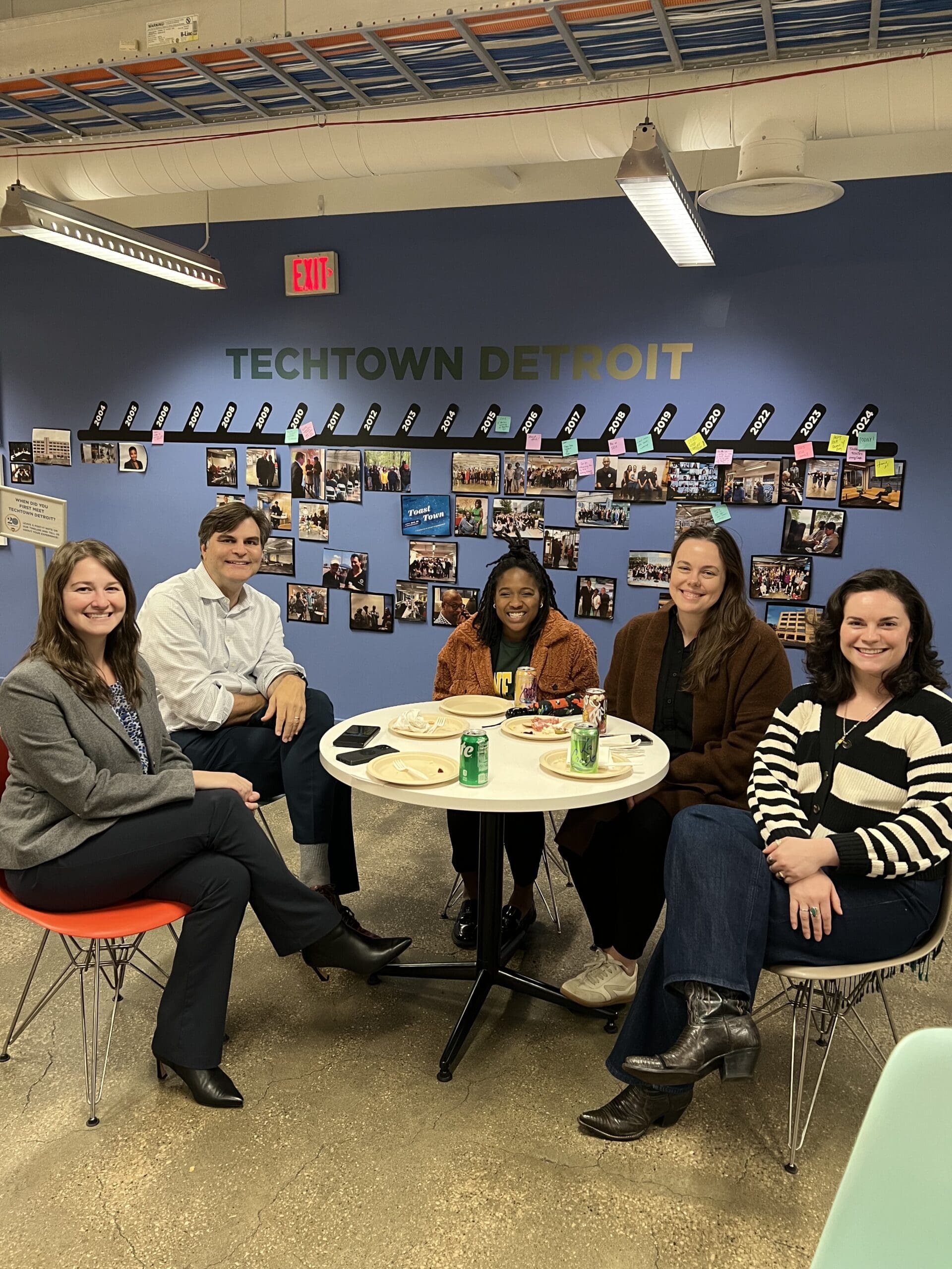 Image of five TechTown team members sitting and smiling at a table.