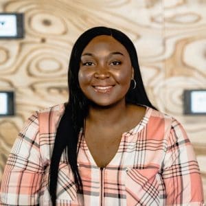 Catalyst Angel Program Angel spotlight is a women of color wearing a plaid shirt 