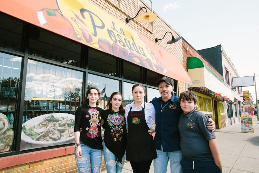Three women, a man, and a boy, pose outside of their family restaurant, La Posada.