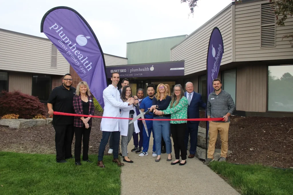 A photo of a ribbon cutting event at one of Plum Health's locations.