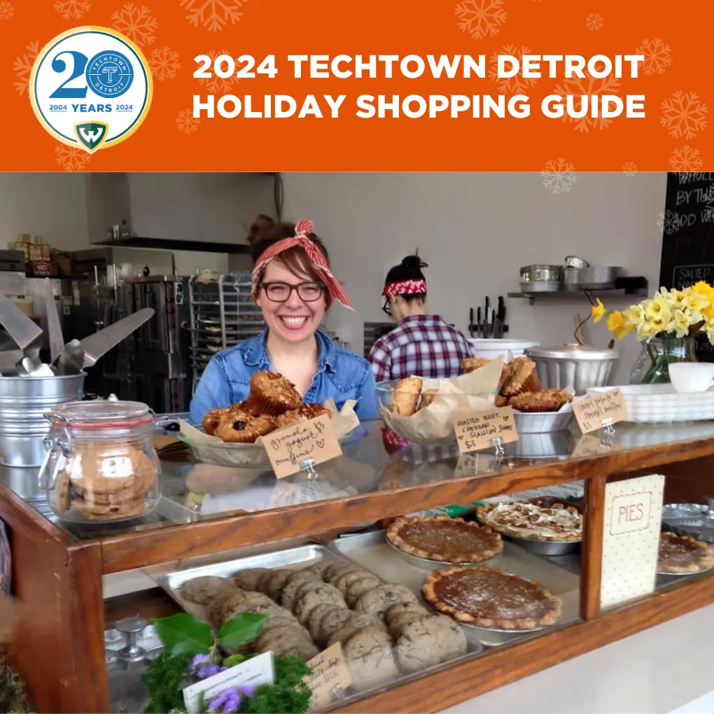 A graphic that reads "2024 TechTown Detroit Holiday Shopping Guide." Under this copy is a photo of Lisa Ludwinski, chef and owner of Sister smiling and standing behind a display of pastries and other baked goods at her bakery