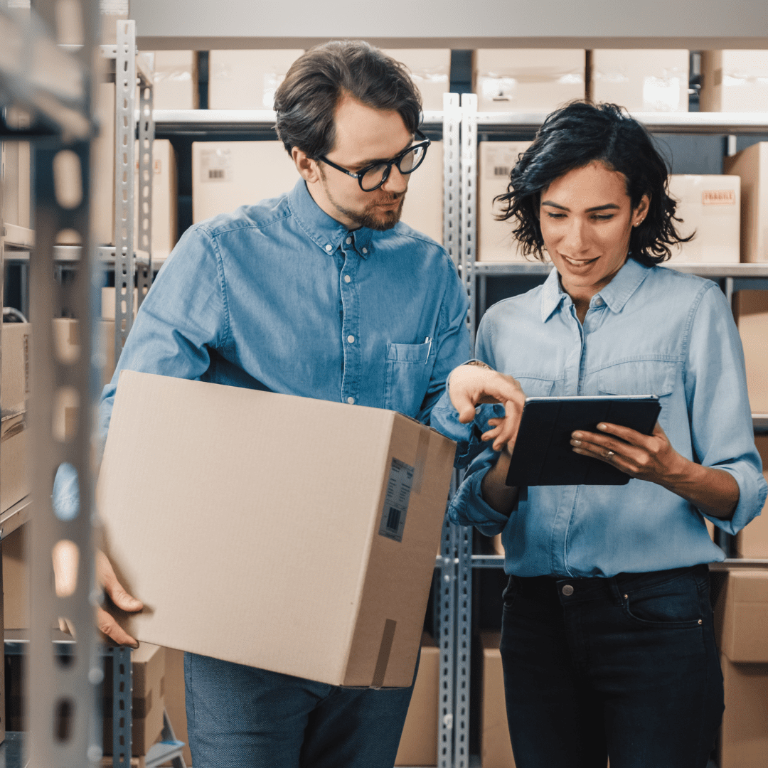 Man asking for direction from women in warehouse regarding exporting international products